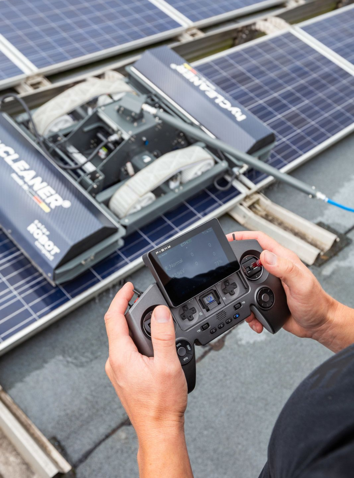 Person using a remote control to operate solar panels on a roof. - imagen 12