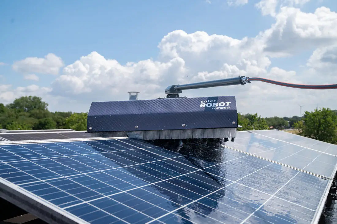 Robot cleaning solar panels on a clear day with blue sky and clouds. - imagen 4
