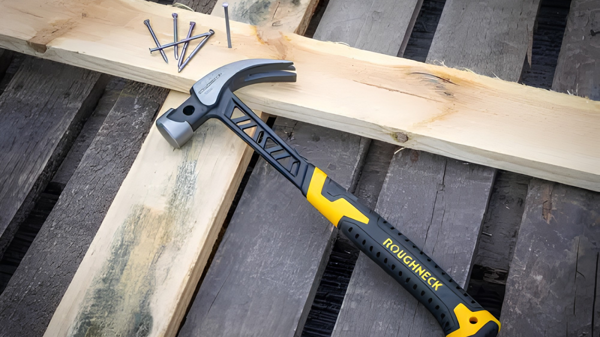 Roughneck 16oz claw hammer with fibreglass shaft on wooden boards beside nails for DIY and carpentry work.