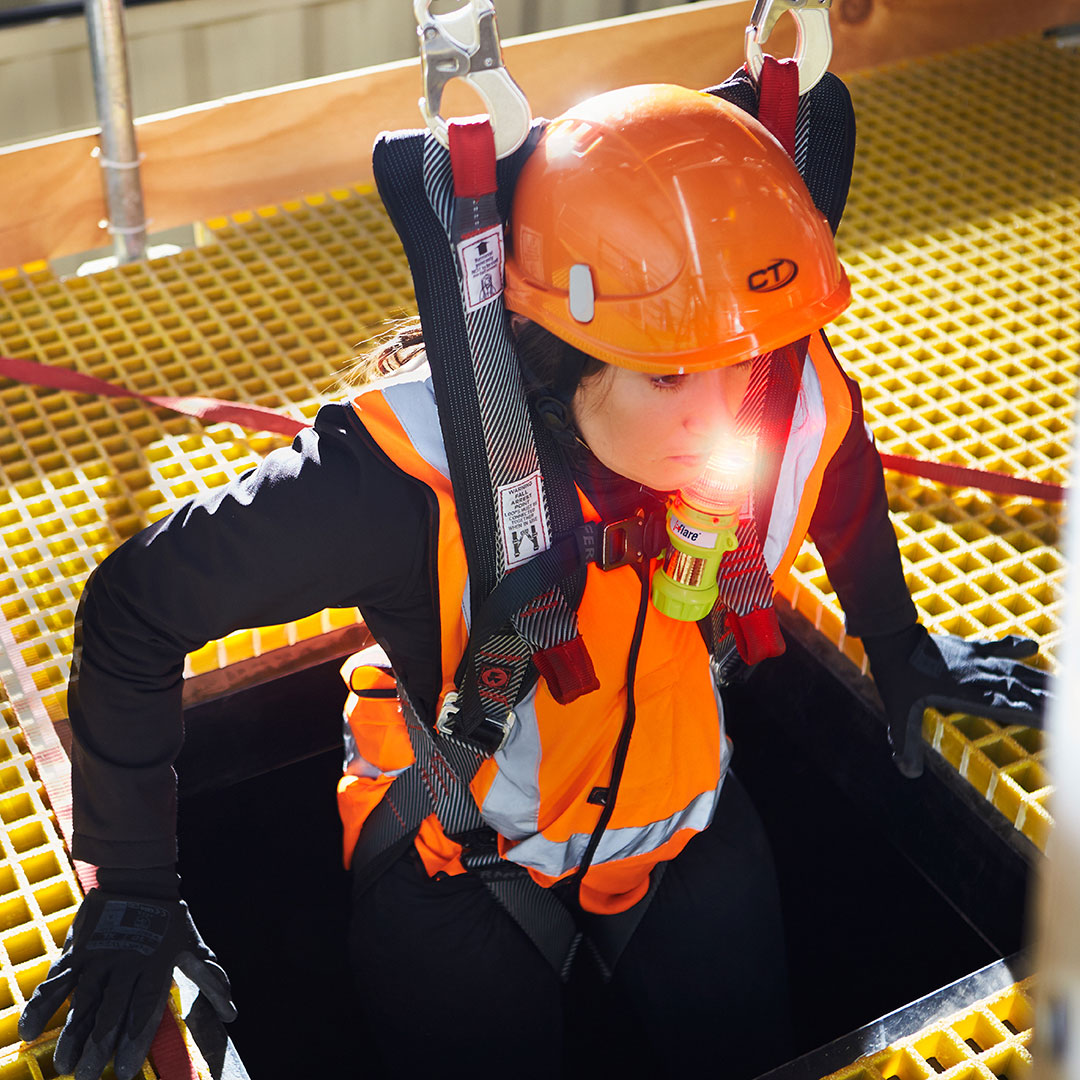 Person in safety gear with a helmet and harness on a yellow platform - imagen 3