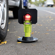 Safety stand with red light on a road next to a car tire - imagen 5
