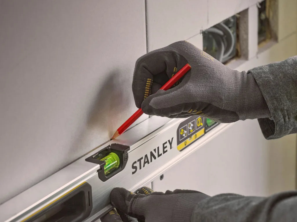 Person using a Stanley level and screwdriver on a wall. - imagen 7